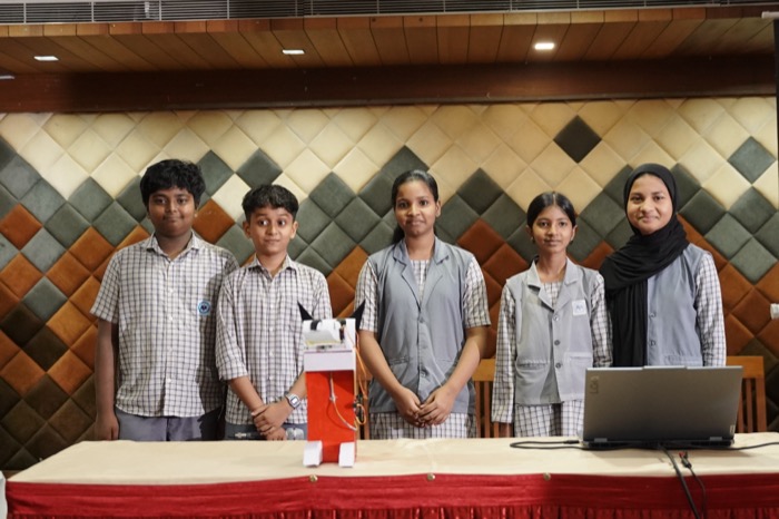 Students presenting the Money Eating Monster smart piggy bank